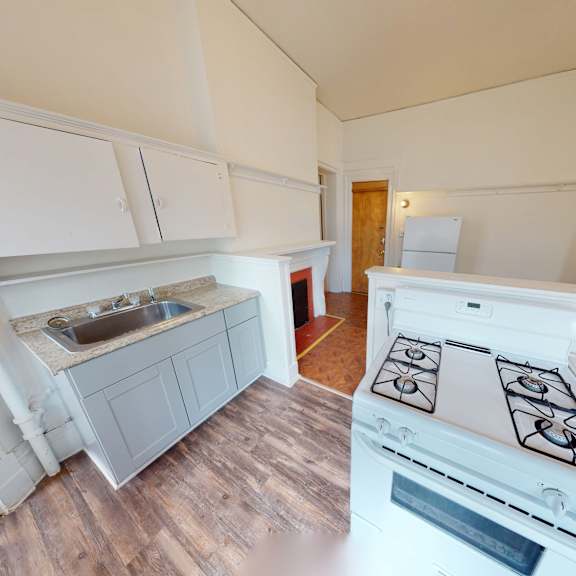 a kitchen with a white stove top oven and a sink.