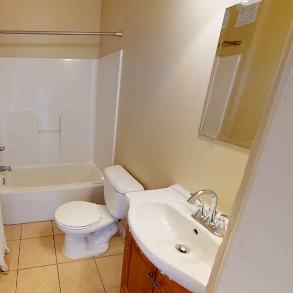 a small bathroom with a toilet, sink, and bathtub.