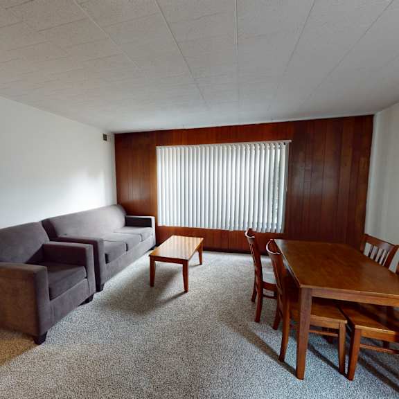 a living room with a brown couch, a brown chair, and a brown table.