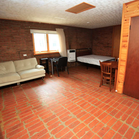 a room with a couch, table, chairs, and a bed.