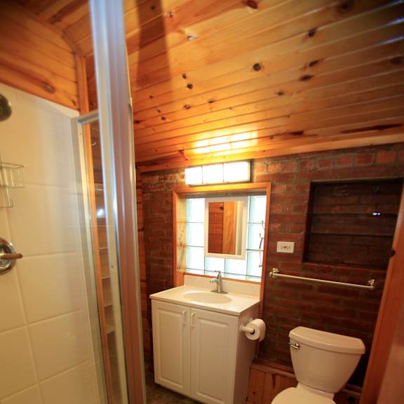 a small bathroom with a toilet, tub and window.