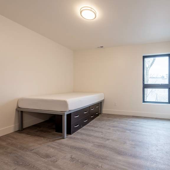 a bedroom with a bed, a window, and a door.