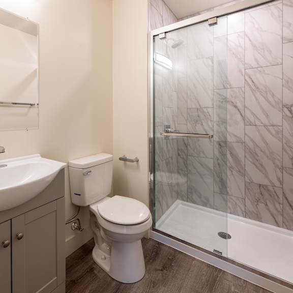 a white toilet sits next to a sink in a bathroom.