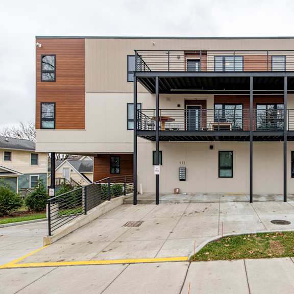 a modern two-story apartment building with a balcony on the second floor.