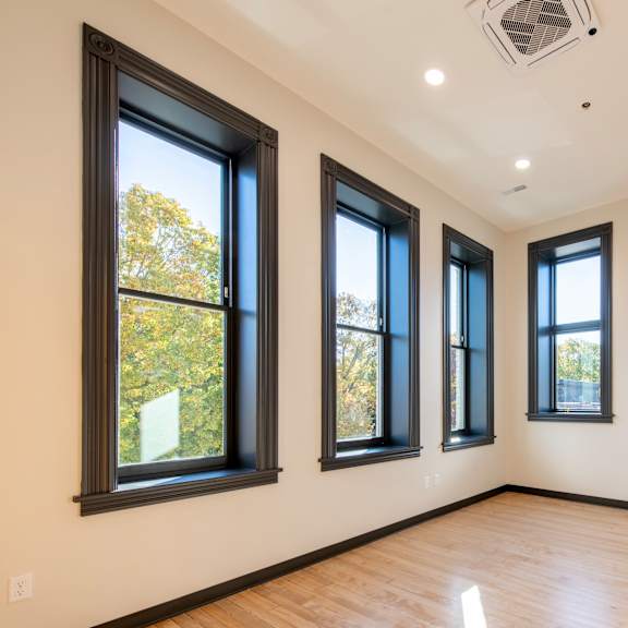 a room with three windows and a wooden floor.