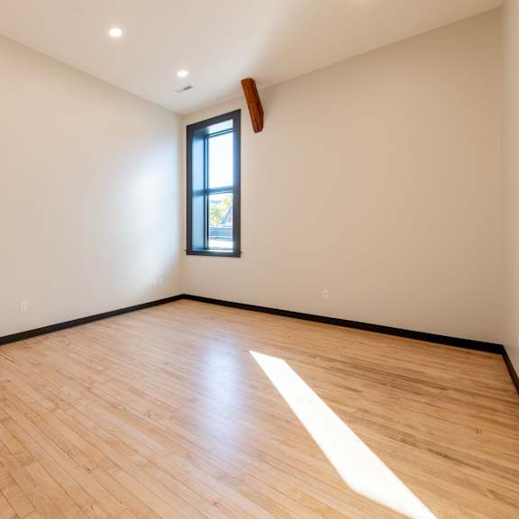 a room with wooden flooring and a window.