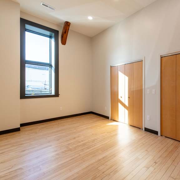 a room with wooden floors and a large window.
