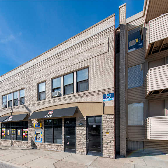 a street view of a building with a blue sign on the right side.