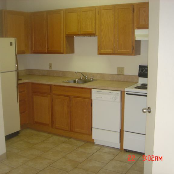 a kitchen with wooden cabinets and white appliances.