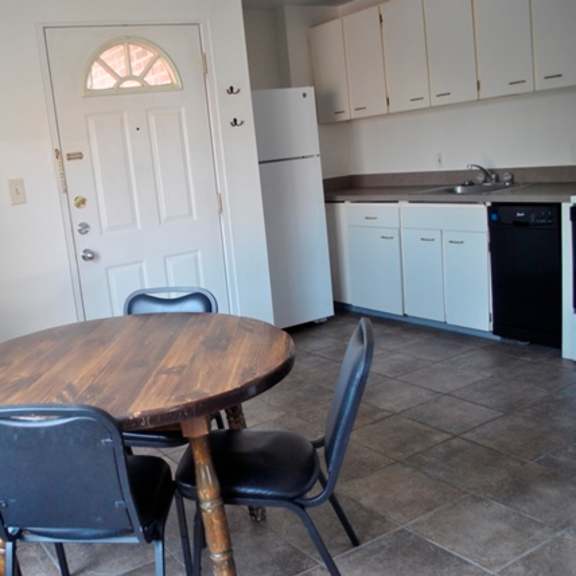 a kitchen with a table and chairs in the foreground.