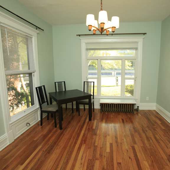 a room with a wooden floor and a table with two chairs.