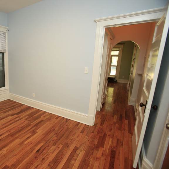 a room with a window and wooden floors.