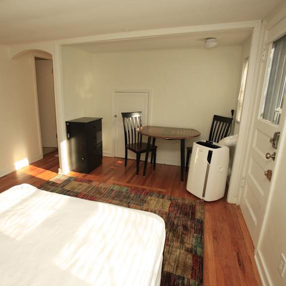 a bedroom with a bed, table and chairs.