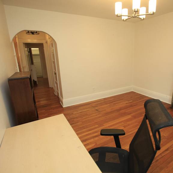 a room with a wooden floor and a black chair.