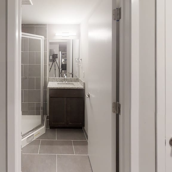 a bathroom with a sink, mirror, and tiled floor.
