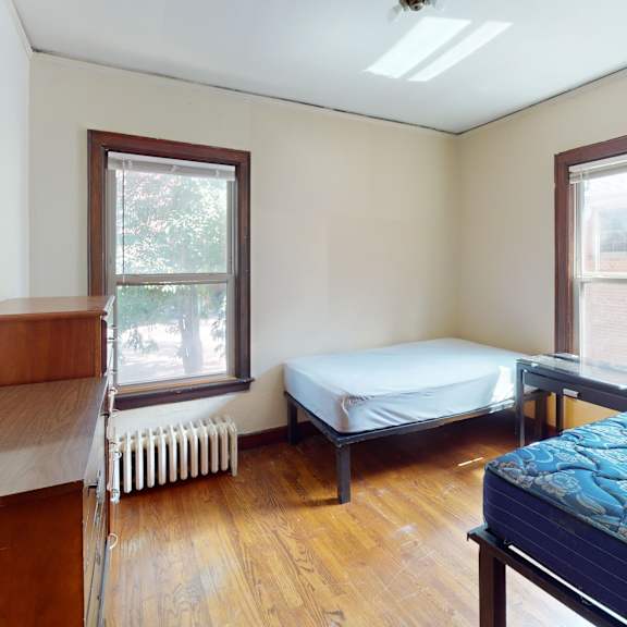 a bedroom with a bed, a window, and a radiator.