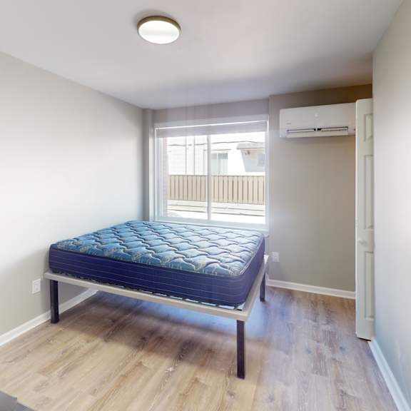 a bedroom with a bed, dresser, and window.