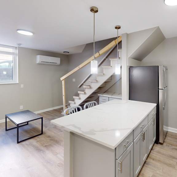 a kitchen with a staircase leading to the upper floor.