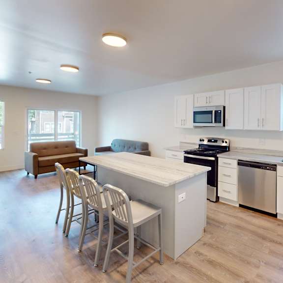 a kitchen with white cabinets and a wooden floor.