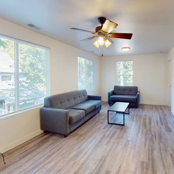 a living room with a grey couch and a black coffee table.