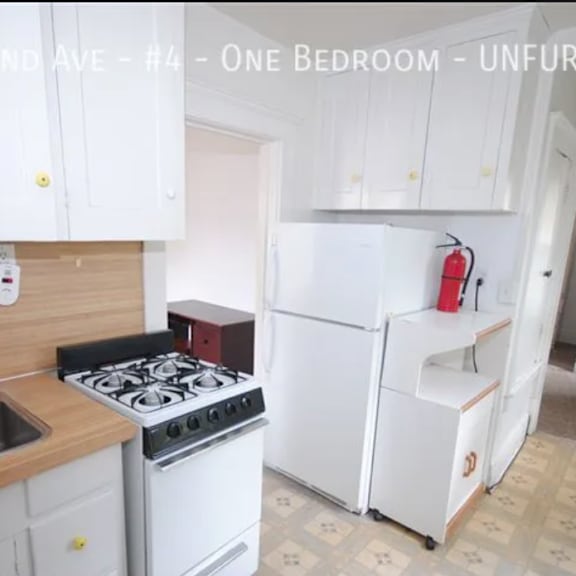 a kitchen with a stove, sink, and refrigerator.
