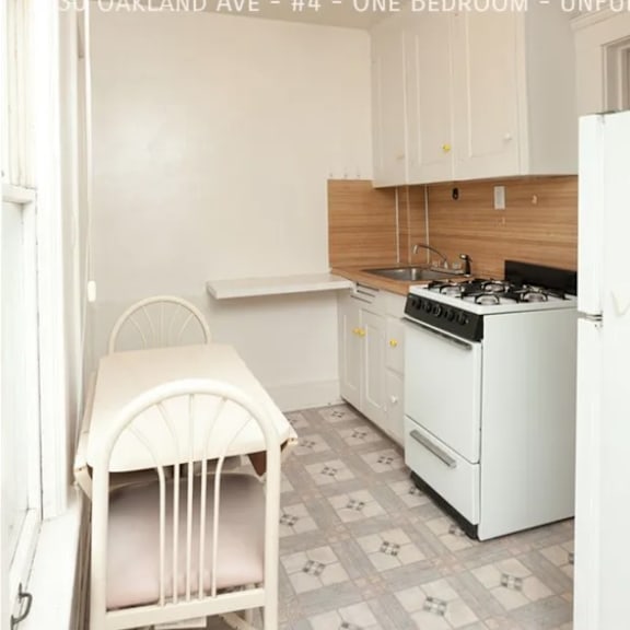 a kitchen with a white chair and a white stove.