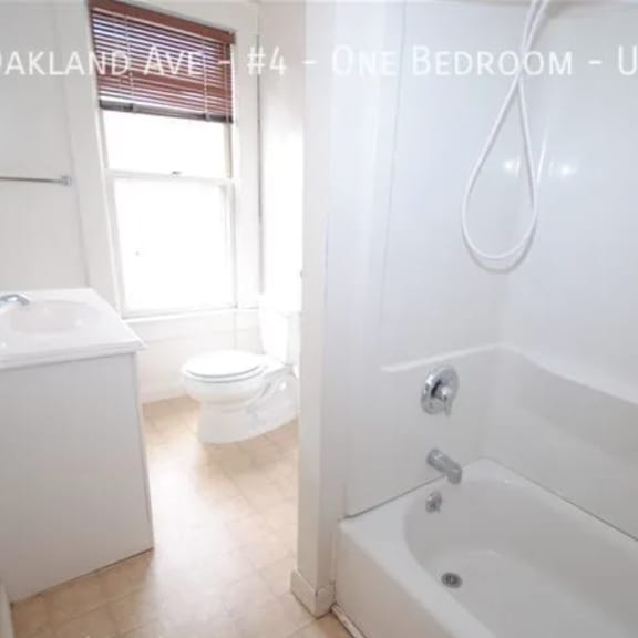 a white bathroom with a tub, toilet and sink.