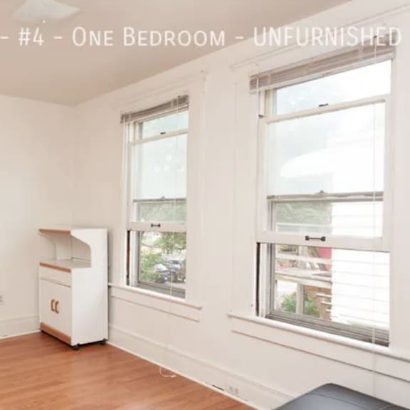 a room with a white fridge and a window.