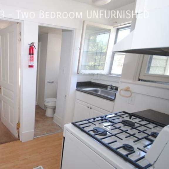 a kitchen with a stove top oven and a fire extinguisher on the wall.