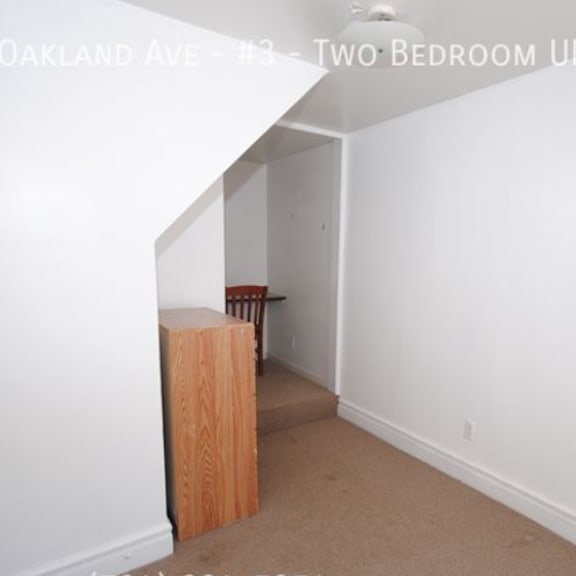 a room with a white wall and a brown box on the floor.