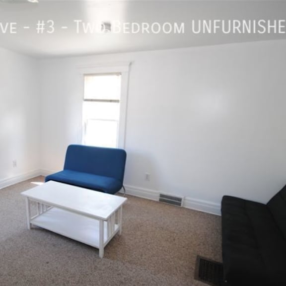 a living room with a blue chair and a white coffee table.