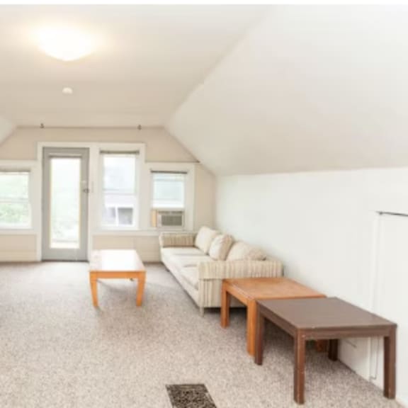 a living room with a couch, coffee table, and bookshelf.
