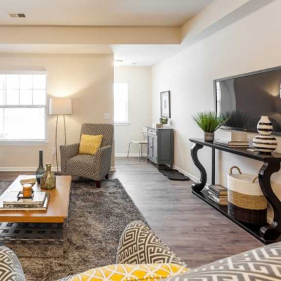 a living room with a white couch, a coffee table, and a television.