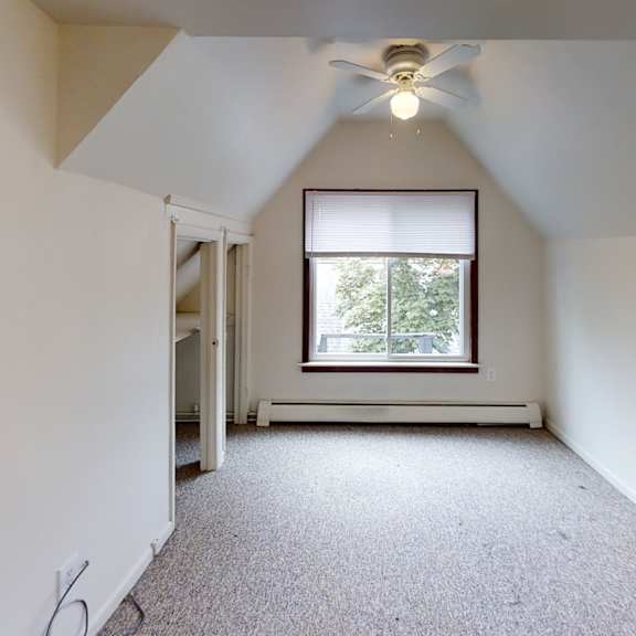 a room with a window and a ceiling fan.