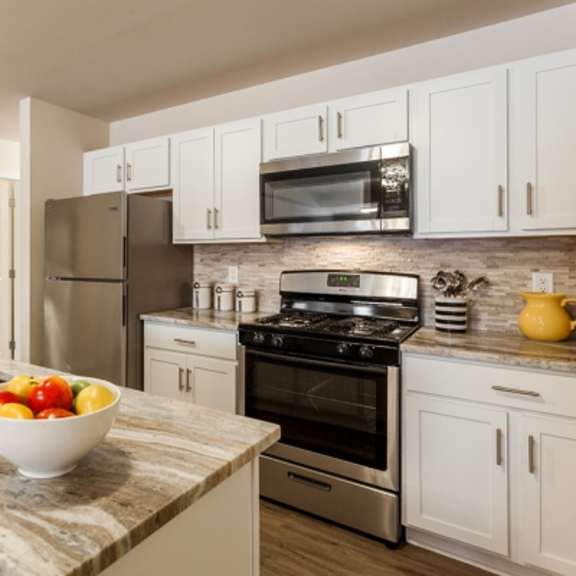 a kitchen with a bowl of fruit on the counter.