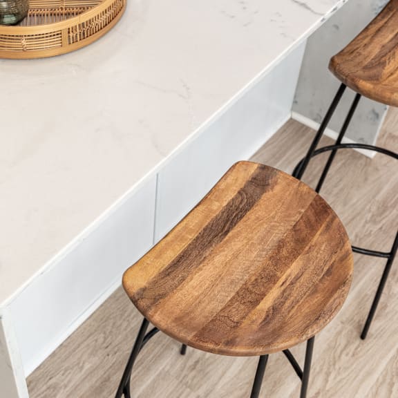 a kitchen with marble counter top and wooden chairs