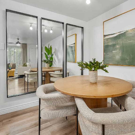 A dining room with a round table and chairs.