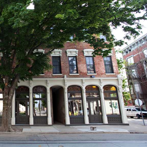 a tree in front of a building on a city street
