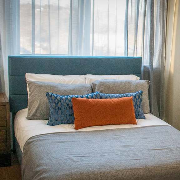 a bed with pillows in a room with a window