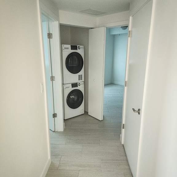 a washer and dryer in a hallway of a home at meridian point at goulds station in miami, fl, 33170
