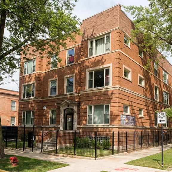a red brick apartment building on the corner of a street