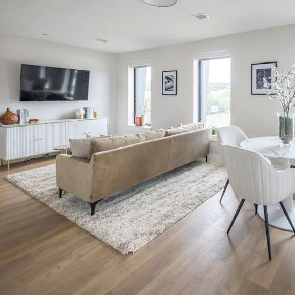 a living room with a couch, chairs, and a television.