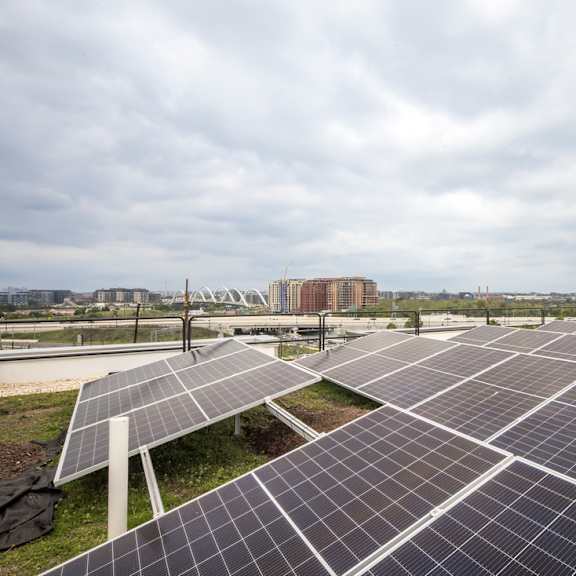 a large solar panel farm with a cloudy sky in the background.
