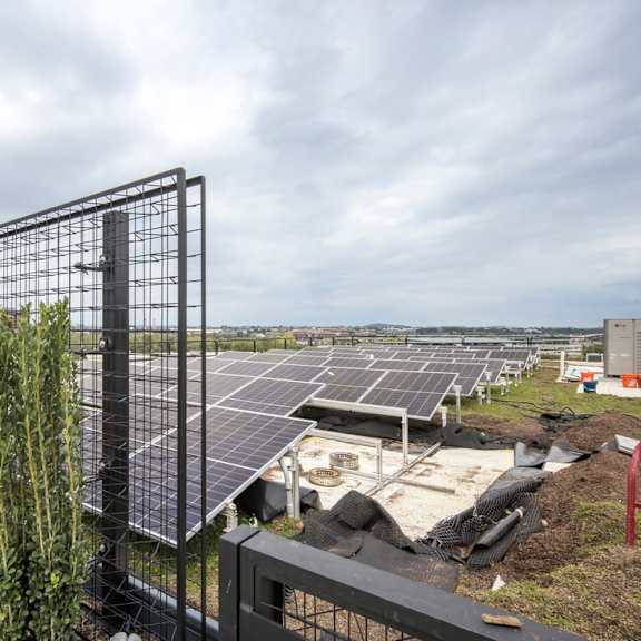a row of solar panels are installed in a field.