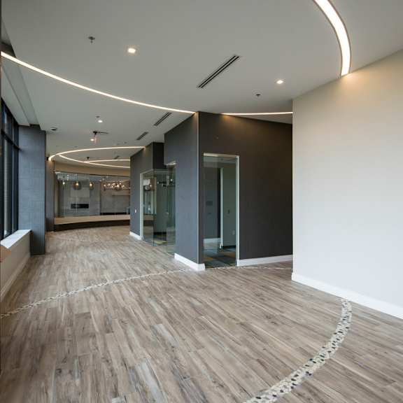 a long hallway with wood floors and white walls.