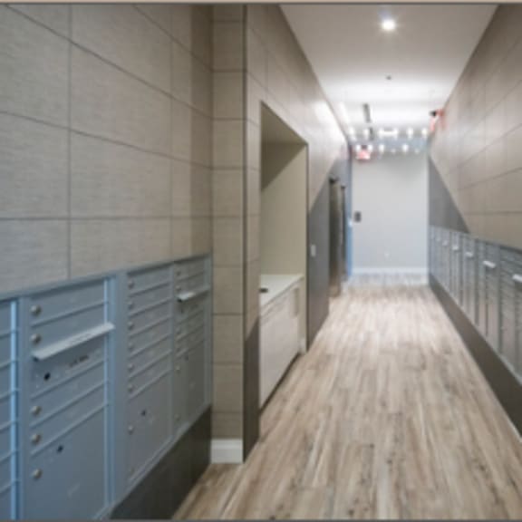 a long hallway with wood floors and grey walls.
