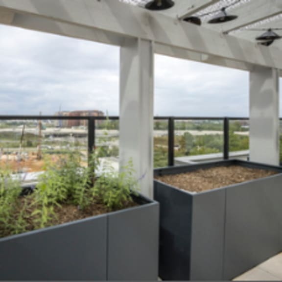 a balcony with grey planters and a view of a construction site.