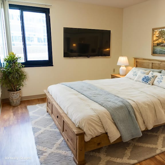 a bedroom with a bed, nightstands, and a painting on the wall.
