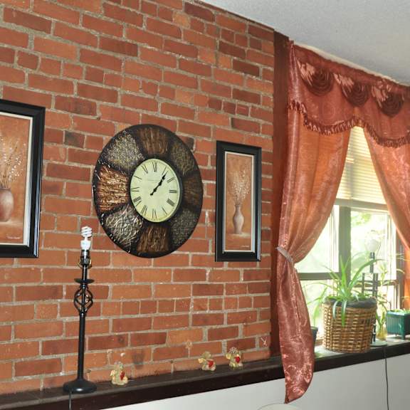 a brick wall with a clock on it next to a window