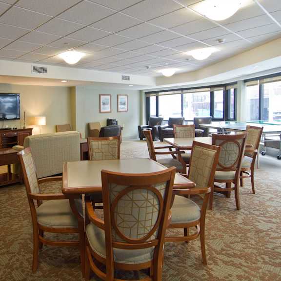 a large room with tables and chairs and a television